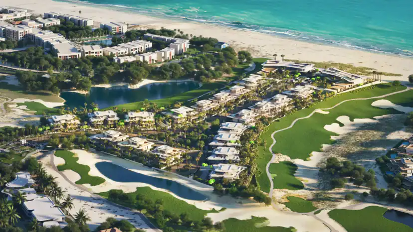Aerial rendering of low-rise white buildings and villas among trees, with a lagoon, a golf course with sand bunkers and a turquoise sea along the shore.