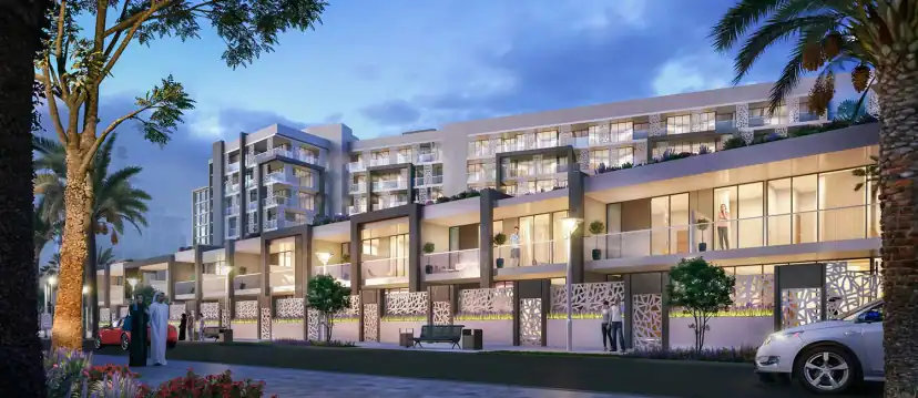 Dusk rendering of a low apartment block with ground-floor townhouse units, patterned screens, lit windows, people on the pavement and a parked white car.