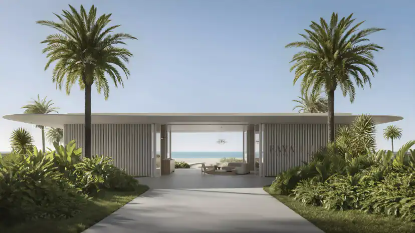 Rendering of an open pavilion with a thin flat curved roof and vertical slats, framed by two tall palm trees and plants, with a sofa and the sea visible through it.
