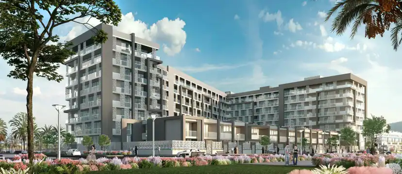 Rendering of a gray and beige apartment building seen from a landscaped garden with pink flowers, trees and lampposts in the foreground.