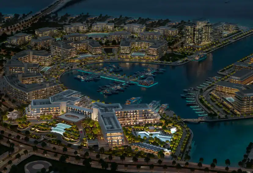 Night aerial rendering of a waterfront community with lit mid-rise buildings around a curved marina filled with boats, and pools among landscaped courtyards.