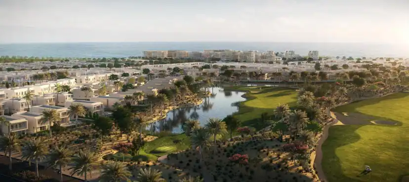 منظر جوي مجسم لفلل بيضاء منخفضة حول بحيرة صغيرة وملاعب غولف خضراء، مع أشجار نخيل والبحر عند الأفق.