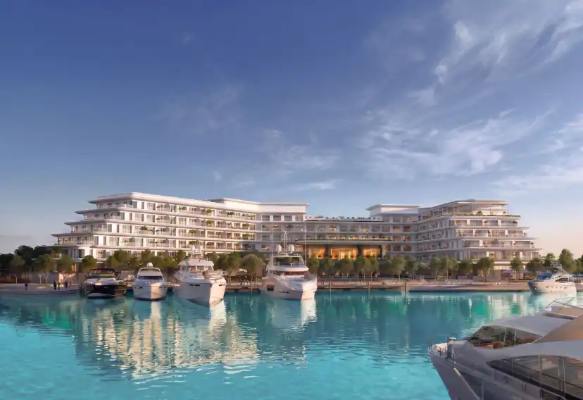Rendering of a white multi-storey waterfront building with stepped balconies, seen across turquoise water where several white yachts are moored.