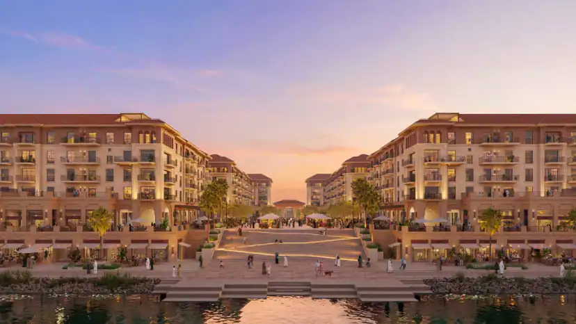 Rendering at dusk of two multi-story buildings facing each other across a wide stepped plaza leading down to the water, with people walking and palm trees.